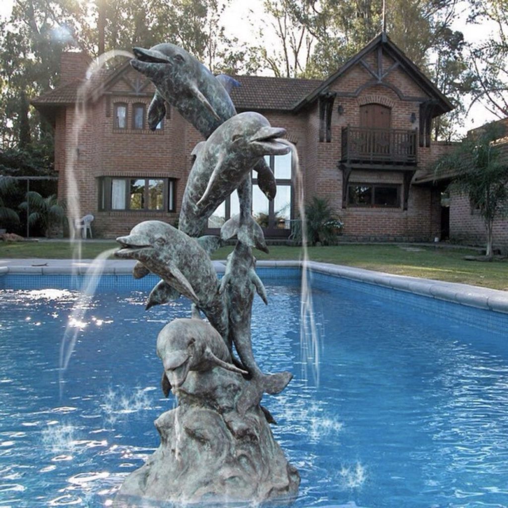dolphin fountain is sculpted in the pool