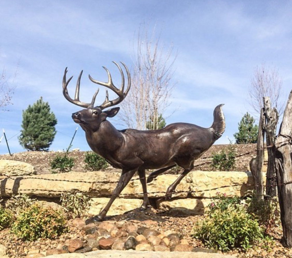 High Tailin whitetail deer Bronze Sculpture by John Parsons